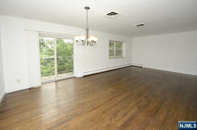 20-30 Ridge Road, Unit A11 Ridgewood, NJ 07450 - Photo 5 of 16 a view of an empty room with wooden floor fridge and a window