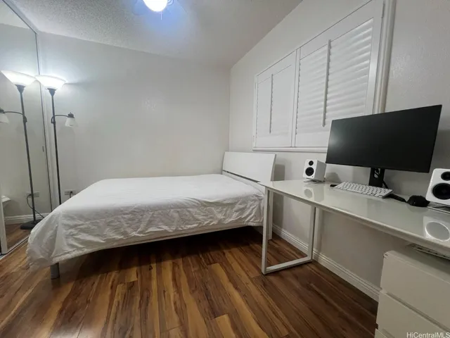 a bedroom with a bed and a flat tv screen on the dresser