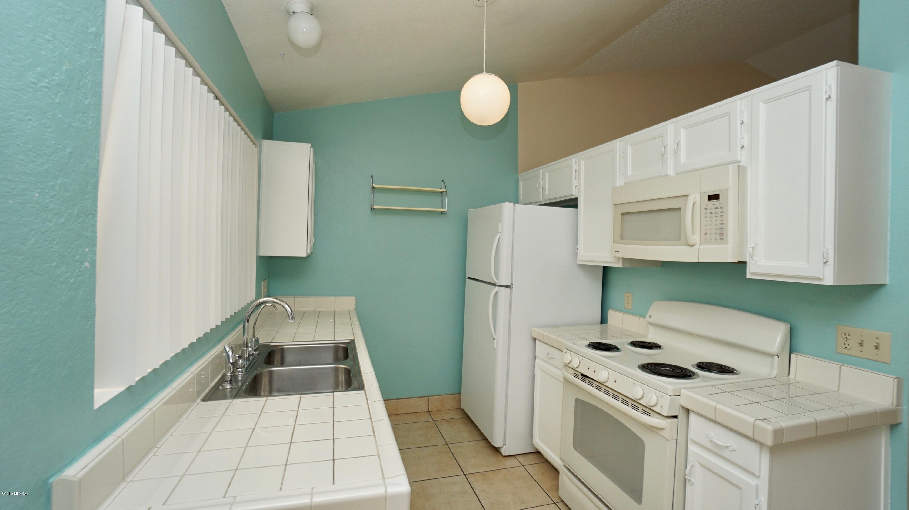 4796 South Lincoln Ridge Drive Tucson, AZ 85730 - Photo 4 of 12 a kitchen with a cabinets and white appliances