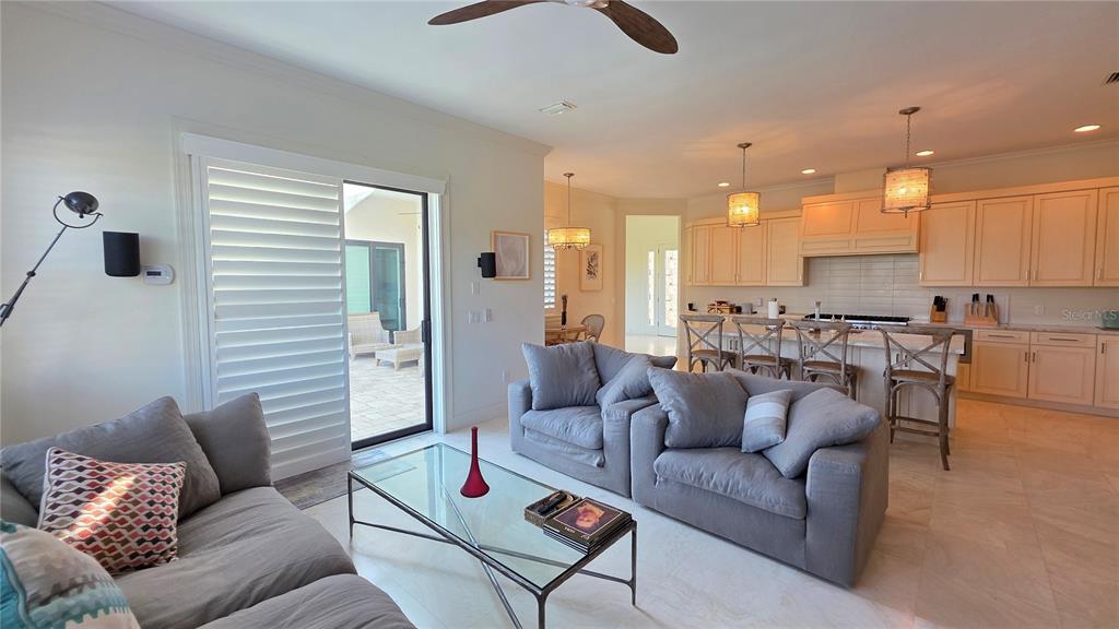 531 Birdie Lane Longboat Key, FL 34228 - Photo 14 of 43 a living room with furniture kitchen view and a chandelier