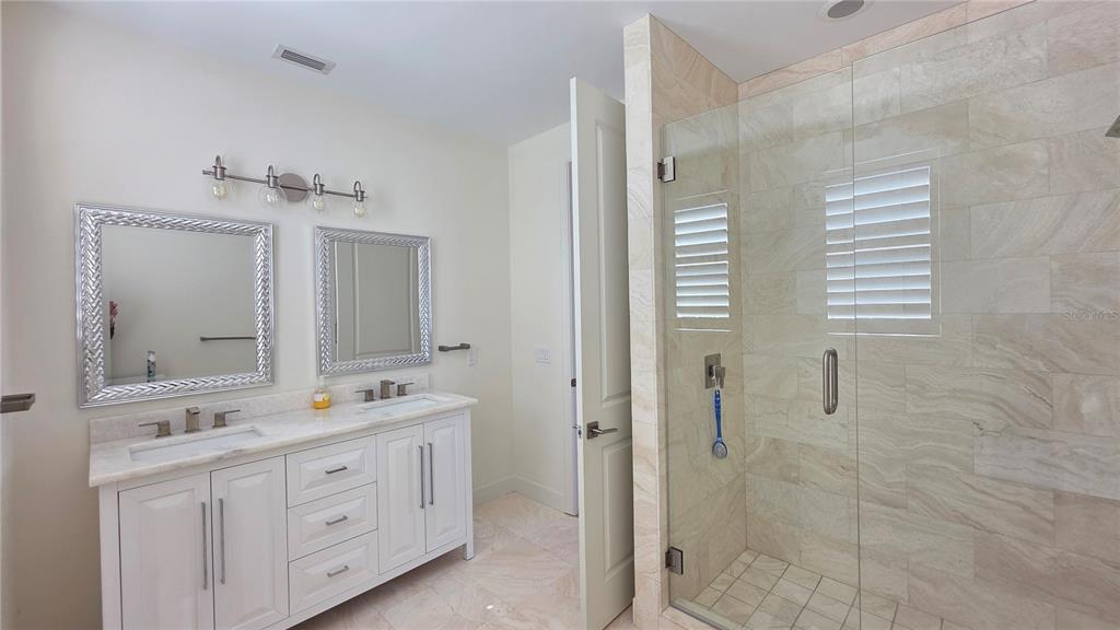 531 Birdie Lane Longboat Key, FL 34228 - Photo 34 of 43 a bathroom with a double vanity sink a mirror and a shower