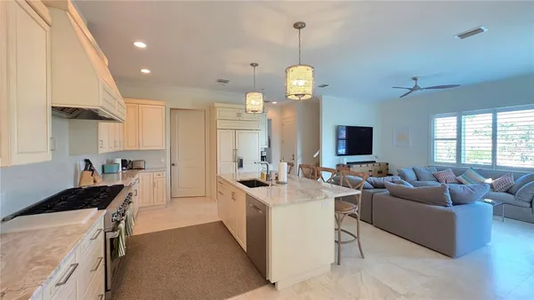 a living room with furniture flat screen tv and kitchen view