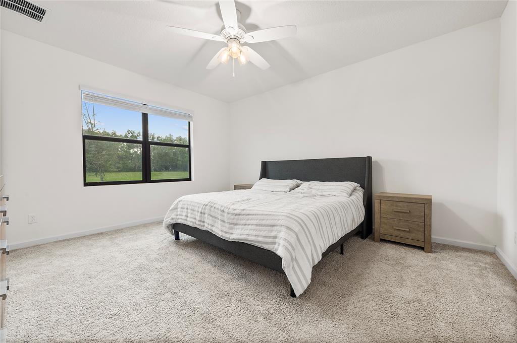 6295 Northwest Regent Street Port St. Lucie, FL 34983 - Photo 12 of 22 a bedroom with a large bed and a window