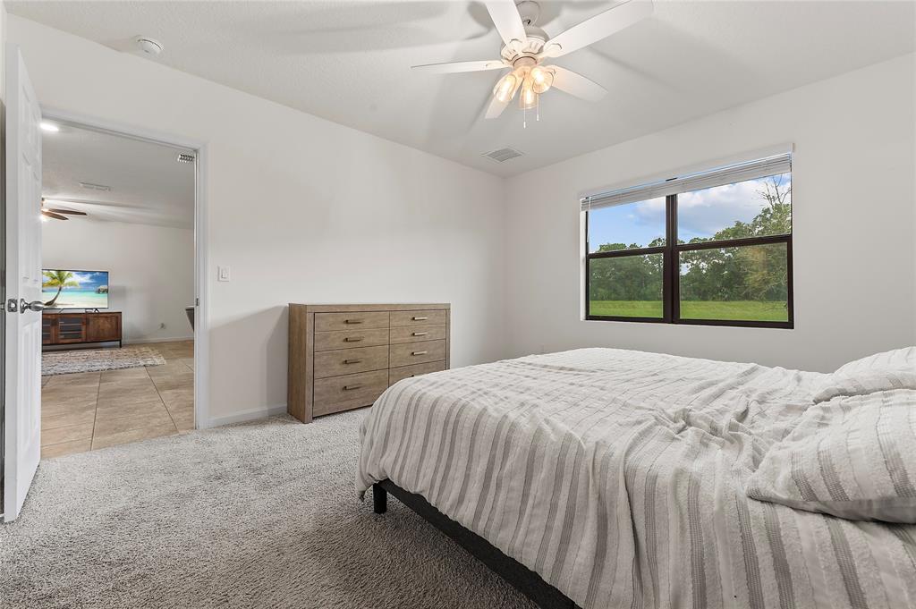 6295 Northwest Regent Street Port St. Lucie, FL 34983 - Photo 13 of 22 a bedroom with a bed and a window