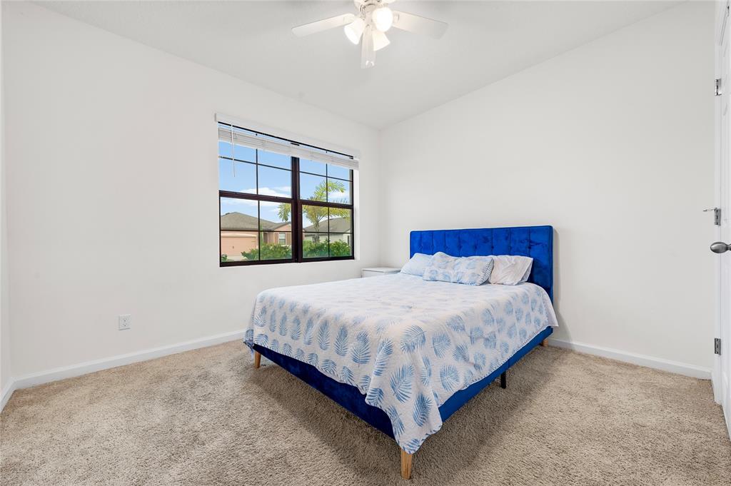 6295 Northwest Regent Street Port St. Lucie, FL 34983 - Photo 16 of 22 a bed sitting in a bedroom next to a window