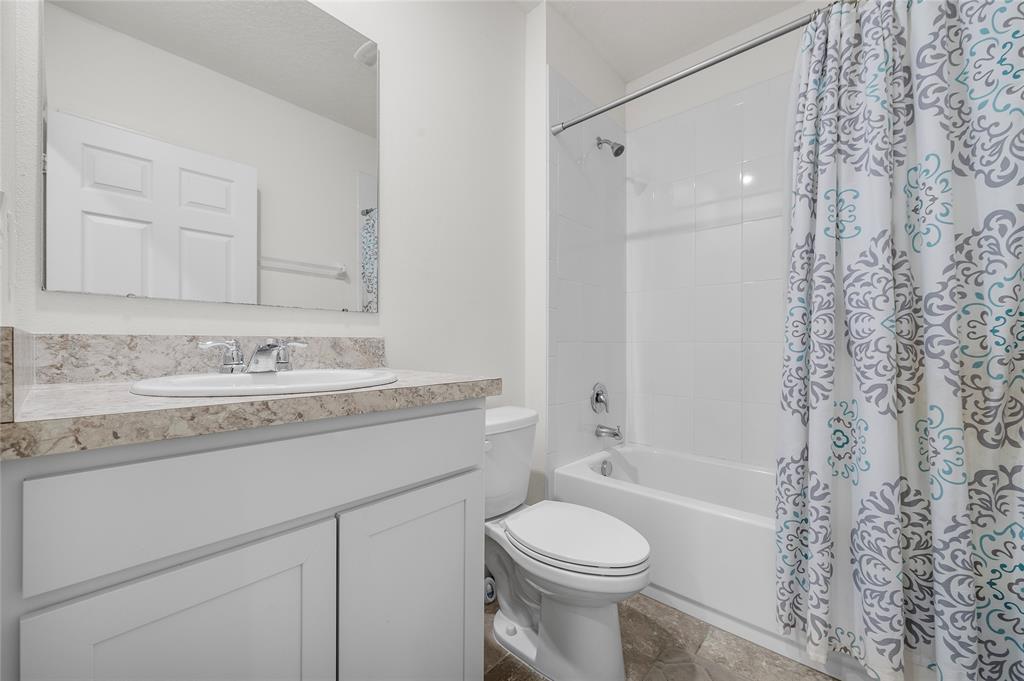 6295 Northwest Regent Street Port St. Lucie, FL 34983 - Photo 18 of 22 a bathroom with a granite countertop sink toilet a shower and a mirror