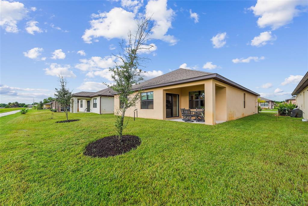 6295 Northwest Regent Street Port St. Lucie, FL 34983 - Photo 20 of 22 a view of a house with a back yard