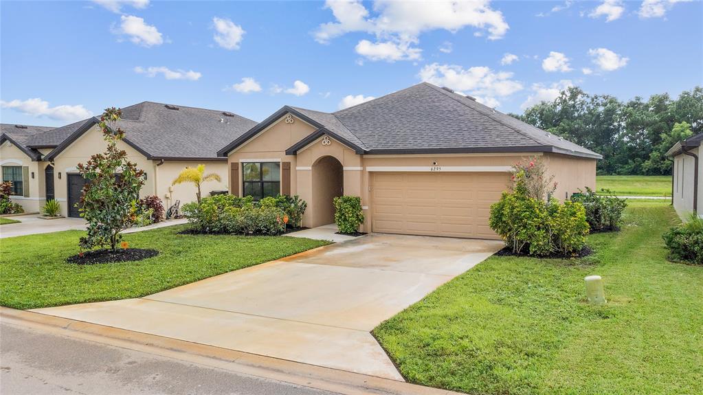 6295 Northwest Regent Street Port St. Lucie, FL 34983 - Photo 2 of 22 a front view of a house with a yard and garage