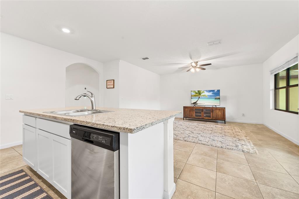6295 Northwest Regent Street Port St. Lucie, FL 34983 - Photo 6 of 22 a kitchen with granite countertop a sink and cabinets