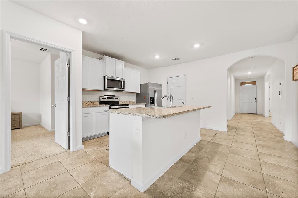 6295 Northwest Regent Street Port St. Lucie, FL 34983 - Photo 7 of 22 a kitchen with stainless steel appliances granite countertop a refrigerator and a sink