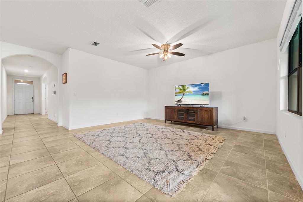 6295 Northwest Regent Street Port St. Lucie, FL 34983 - Photo 8 of 22 a living room with a couch and a chandelier