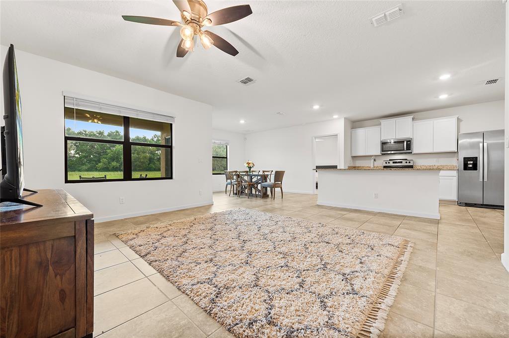 6295 Northwest Regent Street Port St. Lucie, FL 34983 - Photo 9 of 22 a large kitchen with kitchen island a stove a sink a counter space and a window