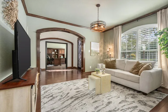 a living room with furniture a flat screen tv and a large window