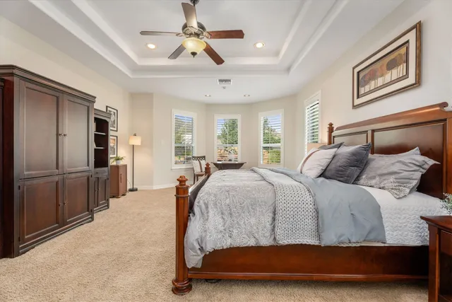 a bed room with a bed and a ceiling fan