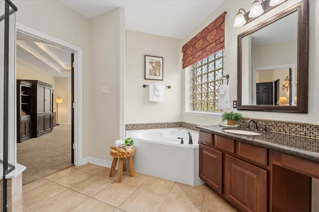 a bathroom with a tub a sink and a mirror