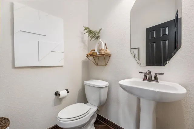 a bathroom with a toilet a sink and mirror