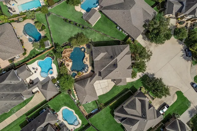 an aerial view of a house with a yard and lake view