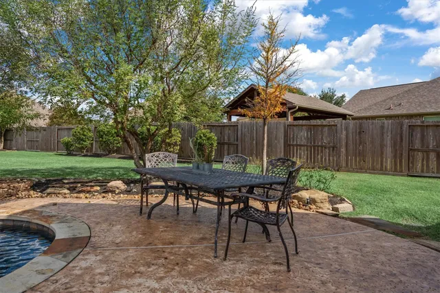 a backyard of a house with table and chairs