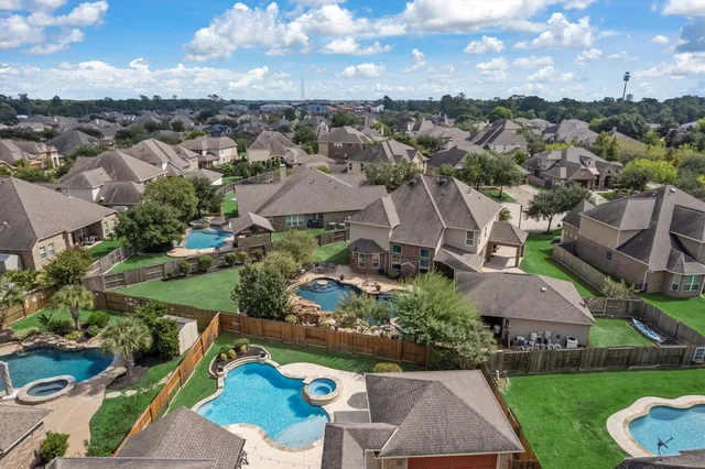 an aerial view of residential houses with outdoor space and street view