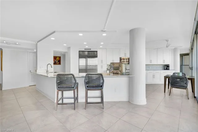 a kitchen with granite countertop white cabinets and stainless steel appliances