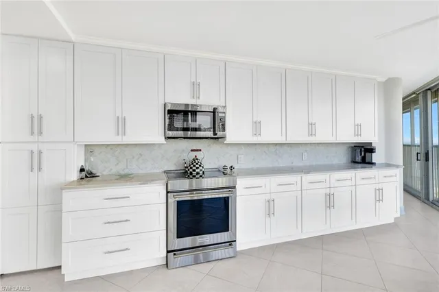 a kitchen with stainless steel appliances kitchen island granite countertop a sink and a refrigerator