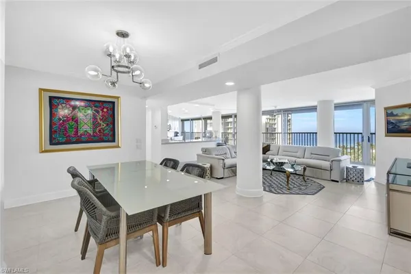 a large white kitchen with lots of counter space and glass door
