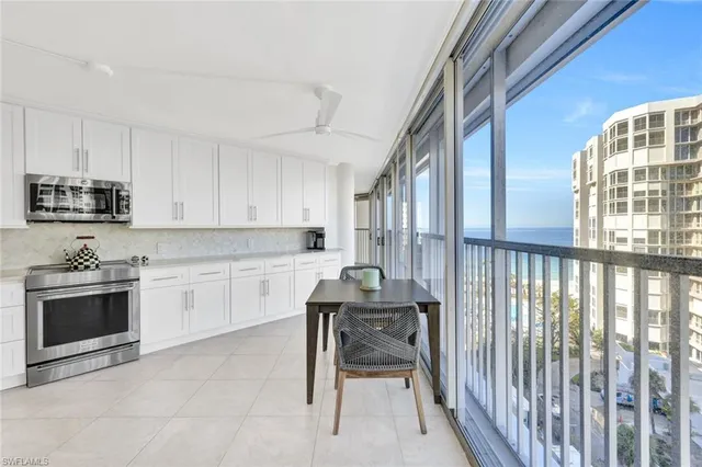 a large white kitchen with white cabinets and a stove