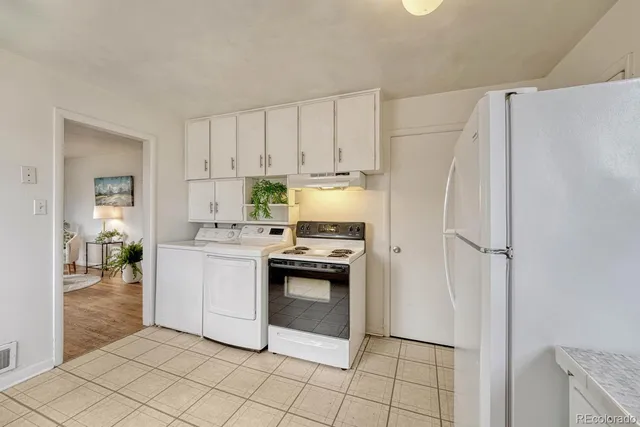 a kitchen with white cabinets and white appliances
