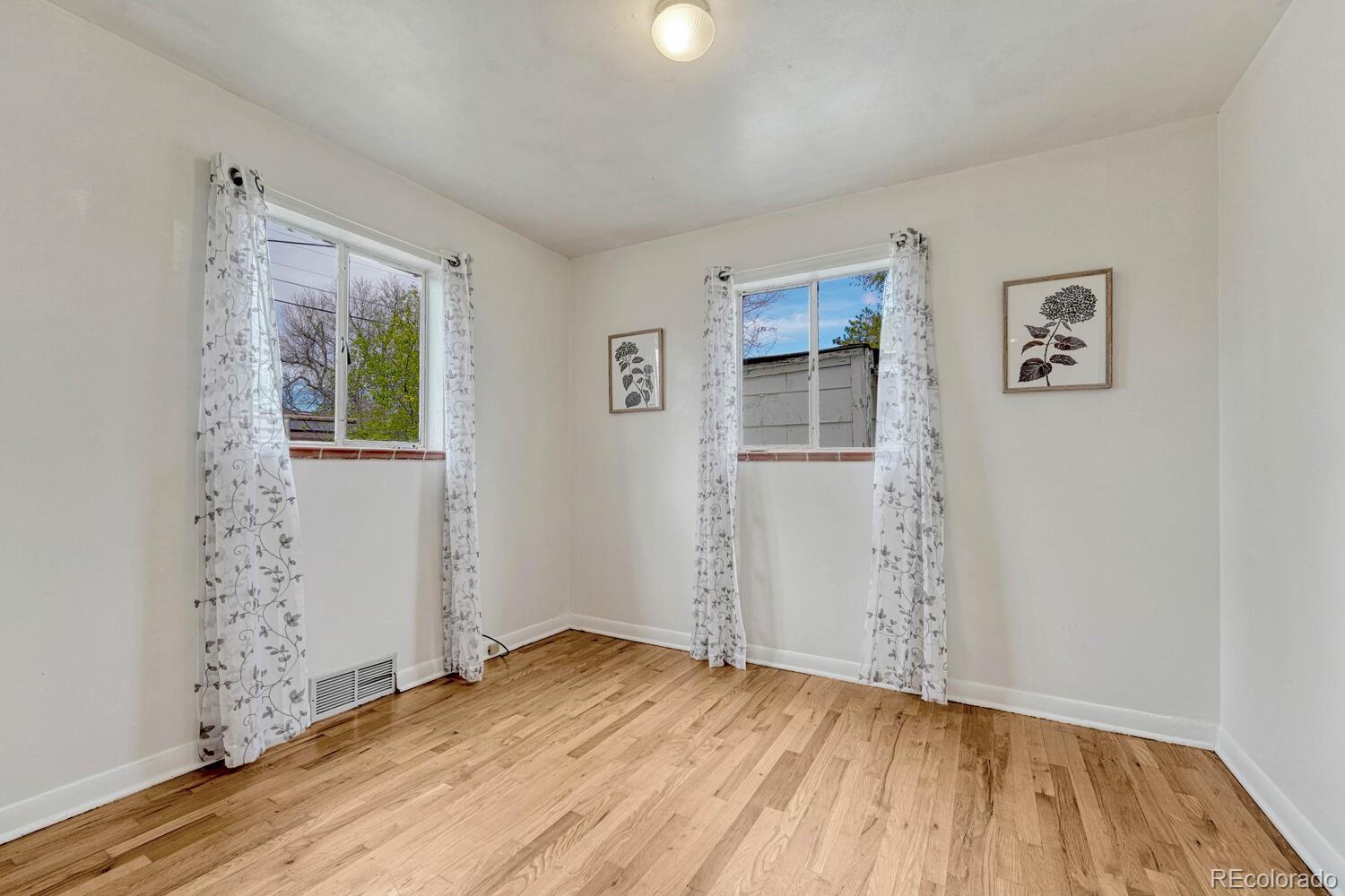 765 Moline Street Aurora, CO 80010 - Photo 16 of 26 an empty room with wooden floor and windows