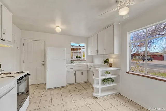 a kitchen with white cabinets and white appliances
