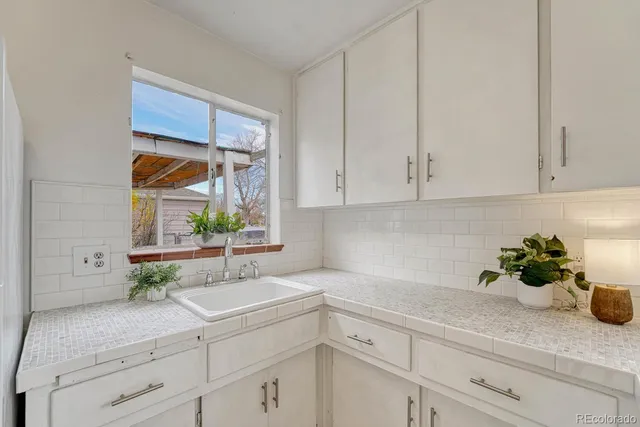 a kitchen with stainless steel appliances white cabinets and a sink