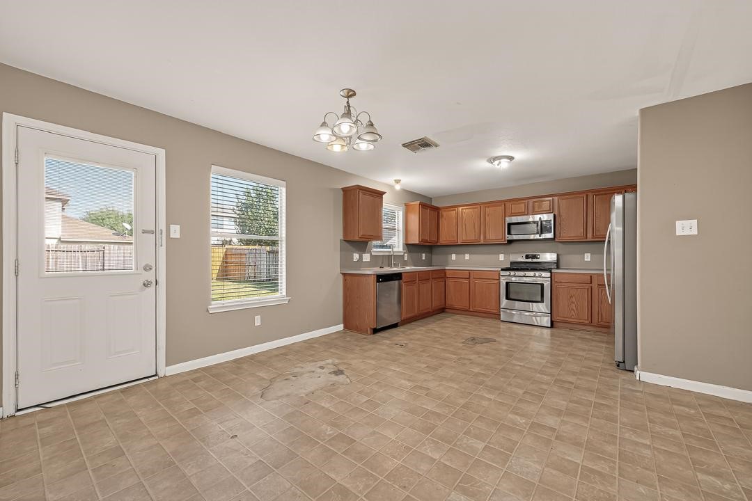 23514 Hidden Maple Drive Spring, TX 77373 - Photo 9 of 23 a large kitchen with stainless steel appliances granite countertop a stove top oven a sink dishwasher and a refrigerator with wooden floor