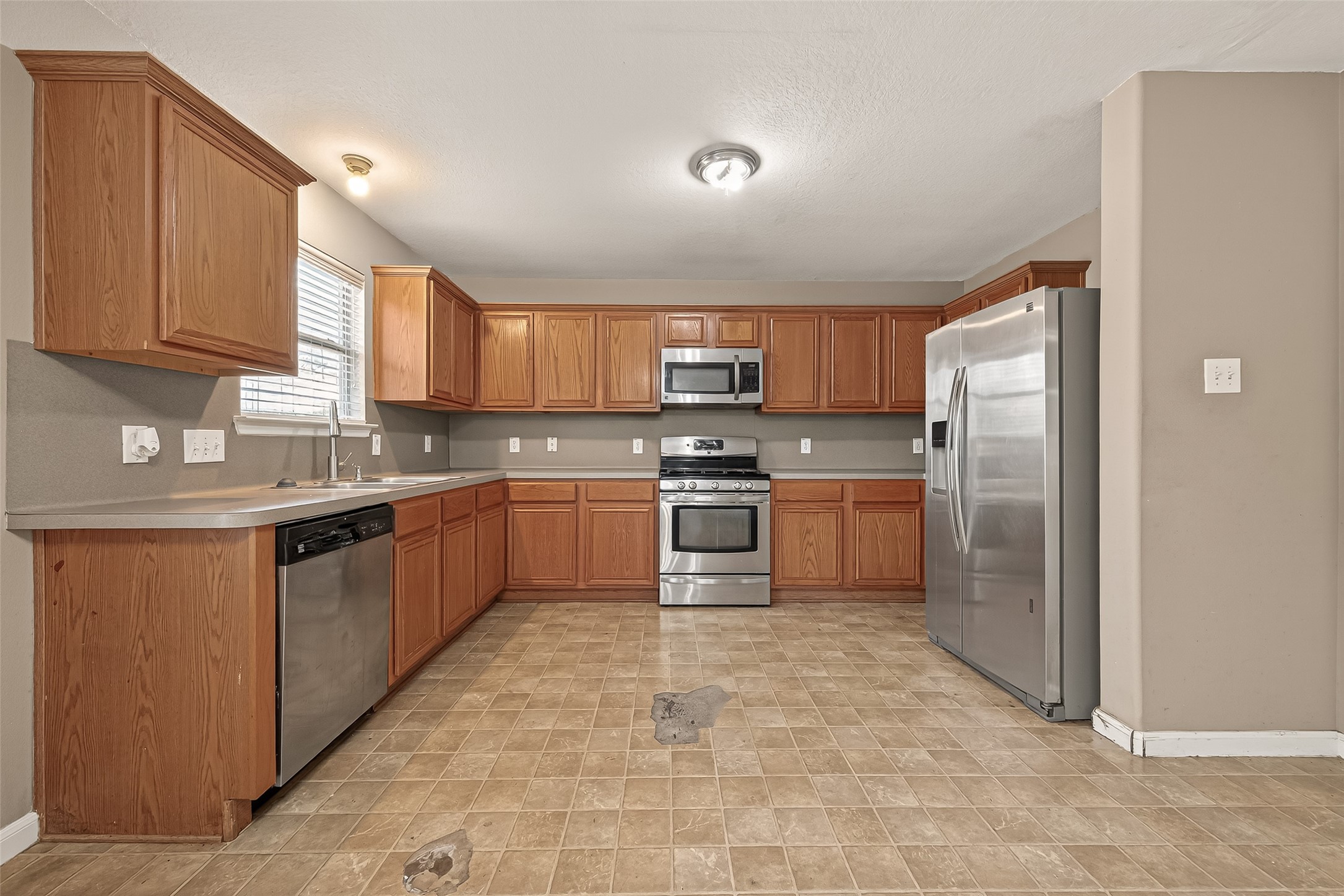 23514 Hidden Maple Drive Spring, TX 77373 - Photo 10 of 23 a kitchen with stainless steel appliances granite countertop a stove refrigerator sink and cabinets