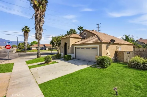 a view of a house with a small yard and a large tree