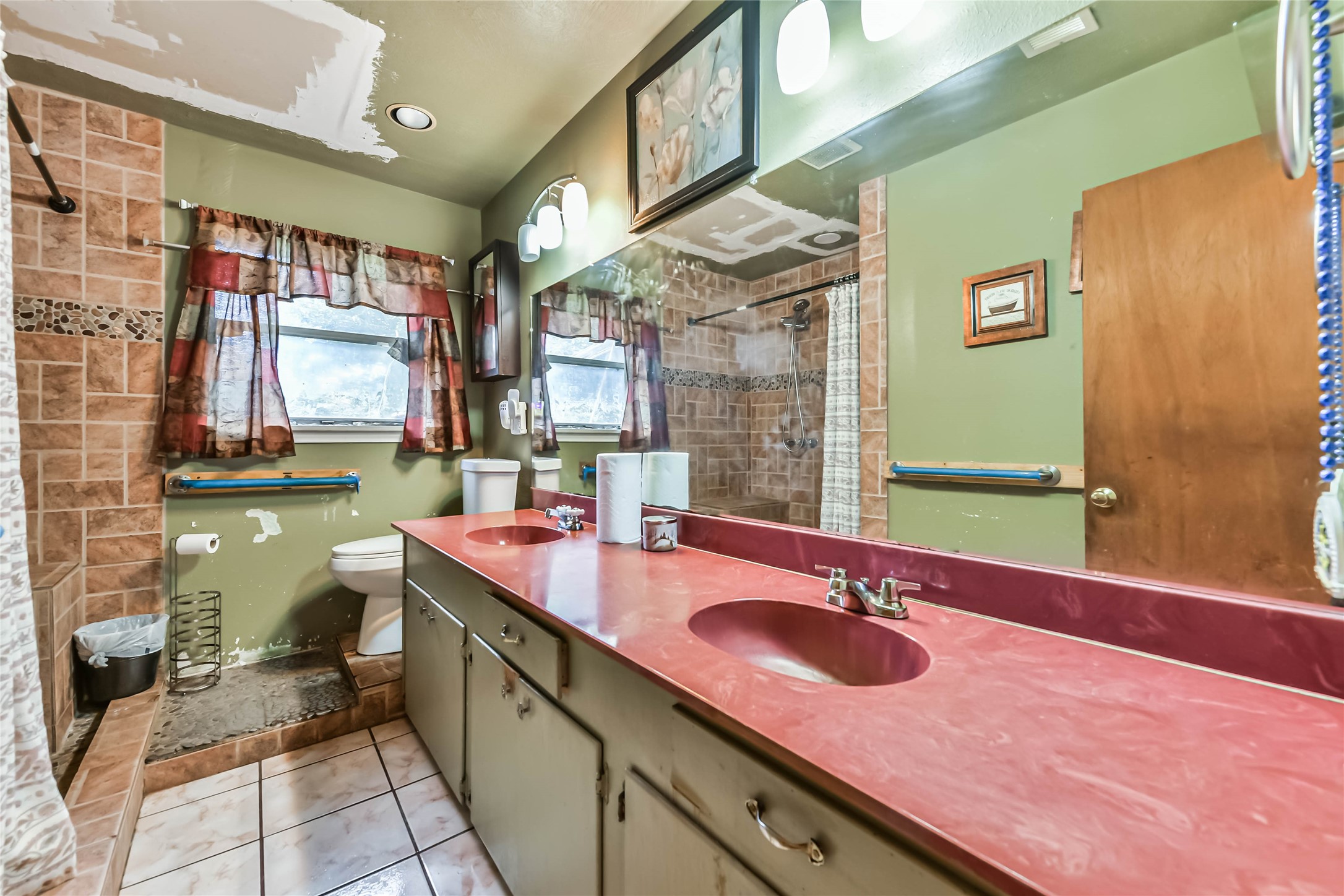 10438 Caxton Street Houston, TX 77016 - Photo 17 of 24 a bathroom with a sink double vanity and a mirror