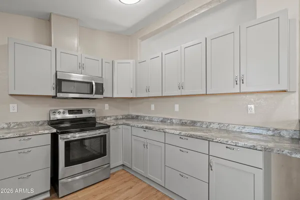 a kitchen with granite countertop white cabinets and stainless steel appliances