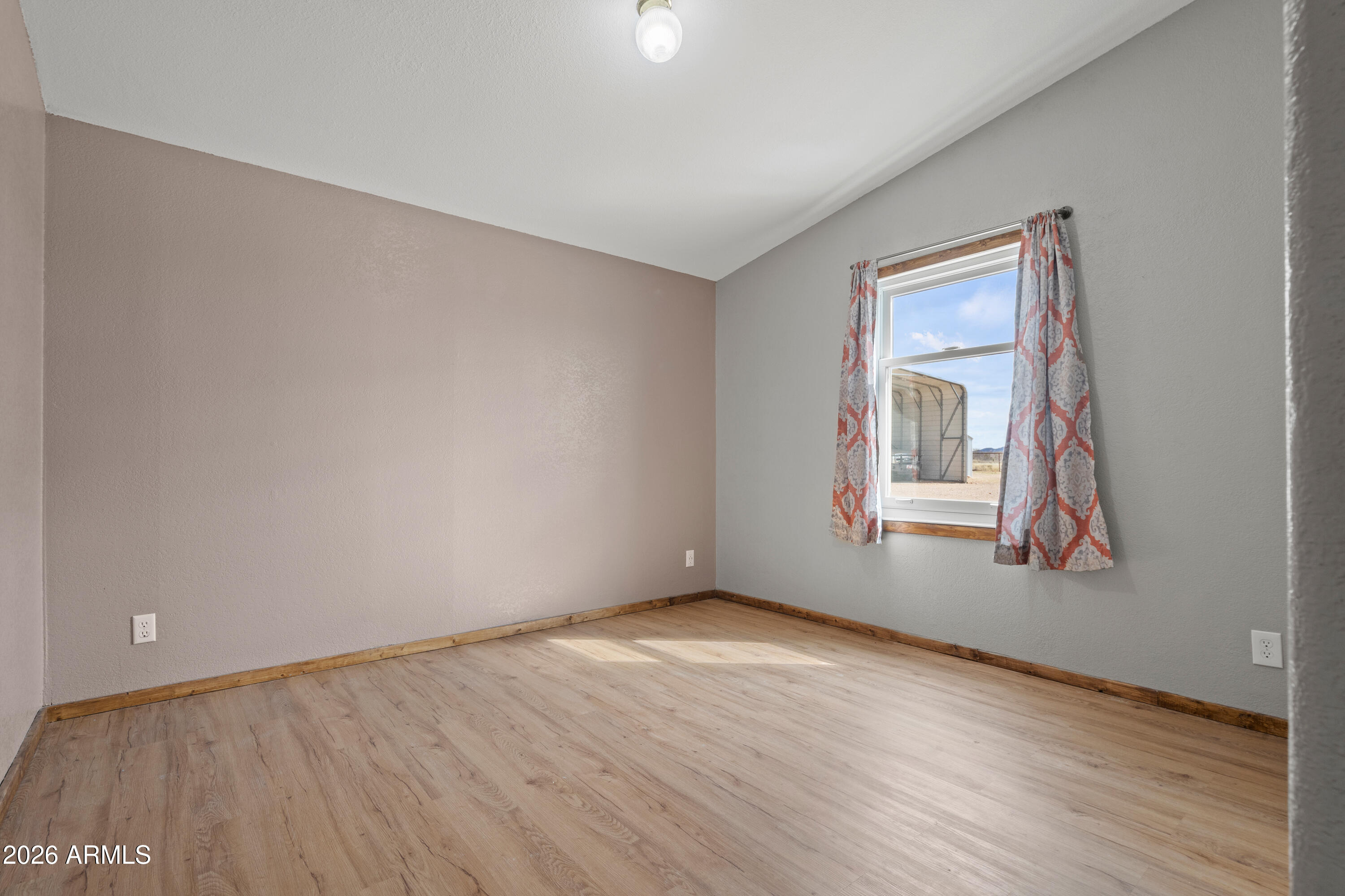10072 South Shiloh Ranch Road Hereford, AZ 85615 - Photo 23 of 46 a view of an empty room with wooden floor and a window