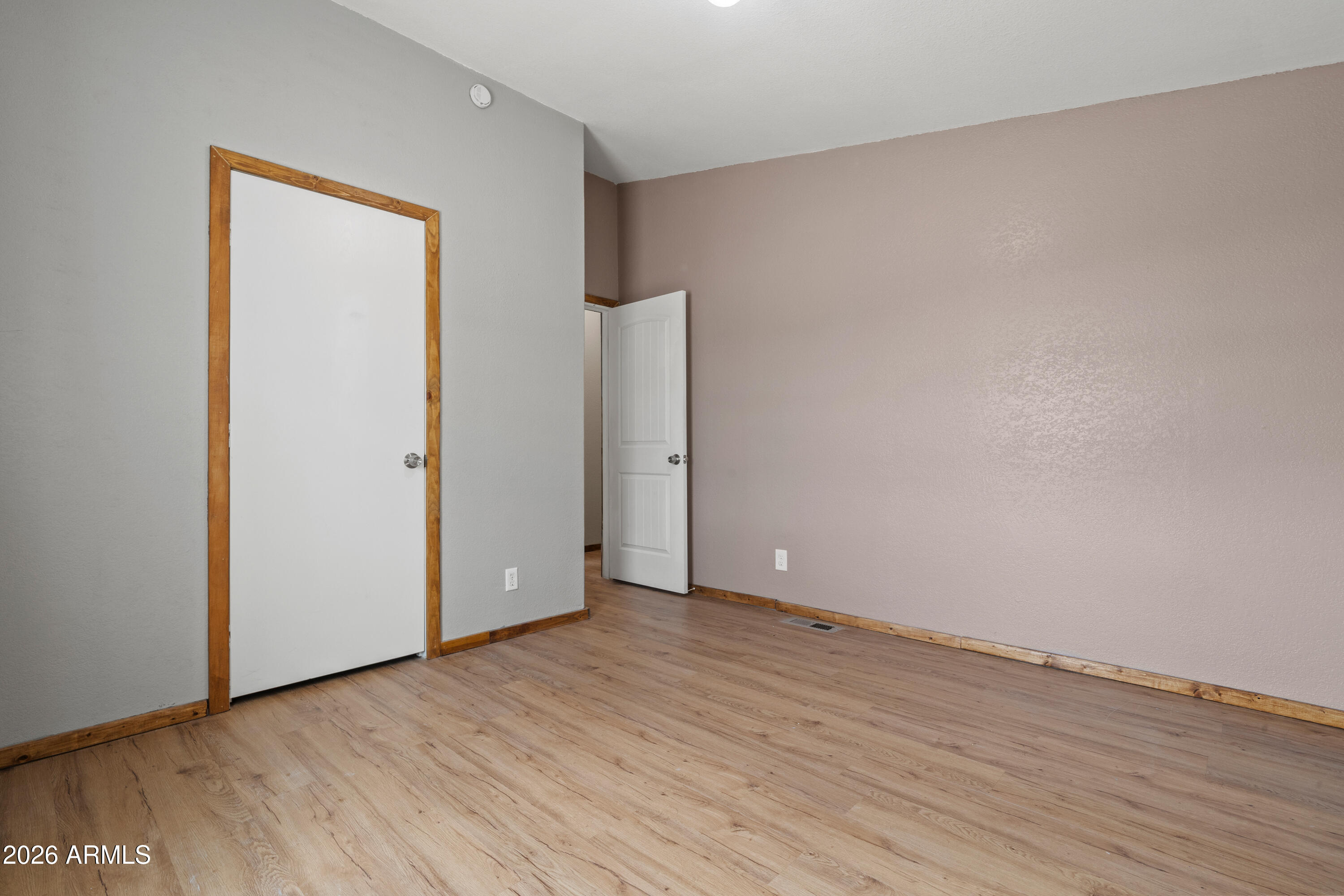 10072 South Shiloh Ranch Road Hereford, AZ 85615 - Photo 24 of 46 an empty room with wooden floor and windows