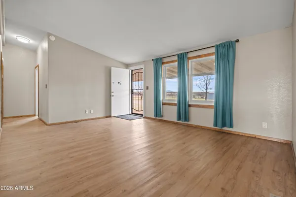 a view of an empty room with glass door and balcony