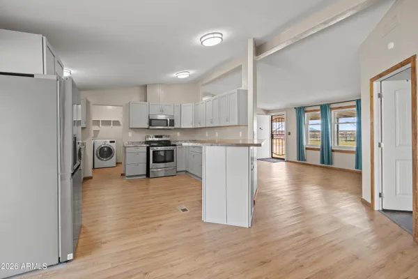 a kitchen with stainless steel appliances granite countertop a refrigerator oven a stove top oven and a refrigerator with wooden floor