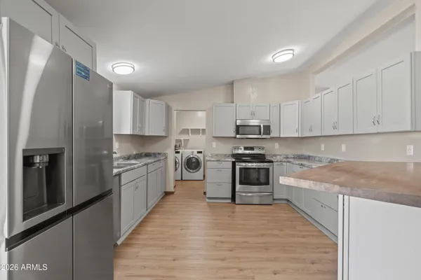 a large kitchen with stainless steel appliances granite countertop a stove a refrigerator and a sink