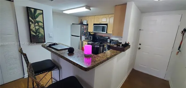 a bathroom with a granite countertop sink a mirror and cabinets