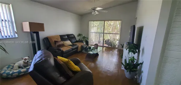 a living room with furniture floor to ceiling window and a potted plant