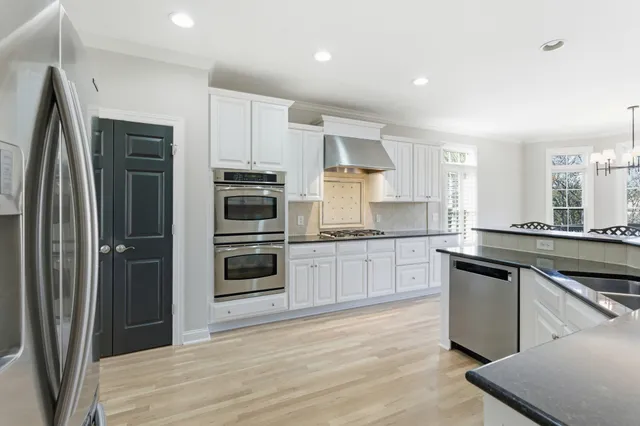 a kitchen with stainless steel appliances granite countertop a refrigerator and a stove top oven