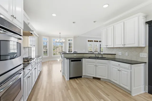 a kitchen with stainless steel appliances granite countertop a stove and a sink