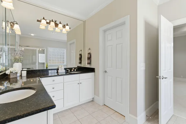 a spacious bathroom with a granite countertop sink a mirror and a shower