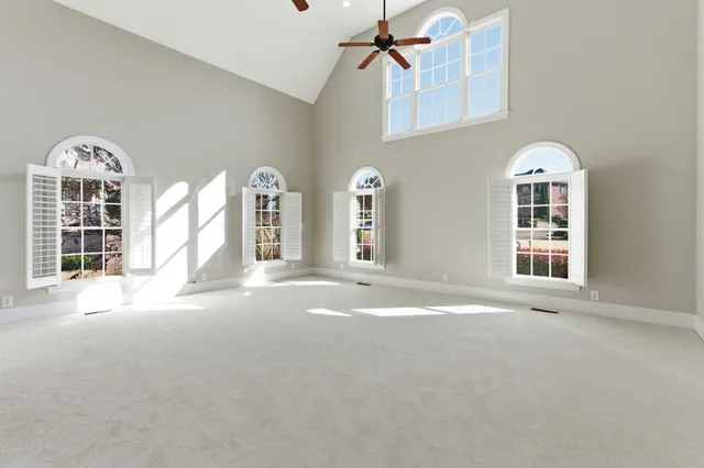 a view of a big room with windows chandelier fan
