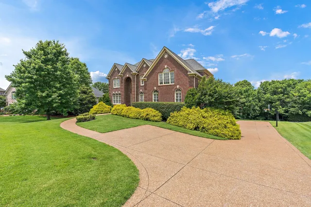 a front view of a house with a yard and trees