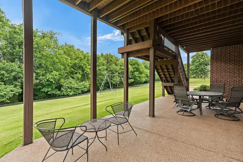 a view of a chairs and table in the patio with a backyard