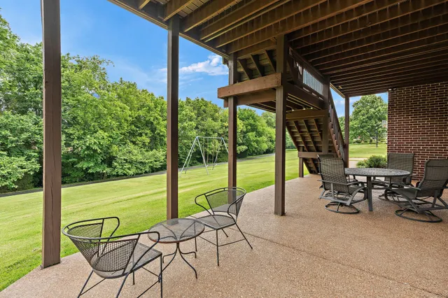 a view of a chairs and table in the patio with a backyard